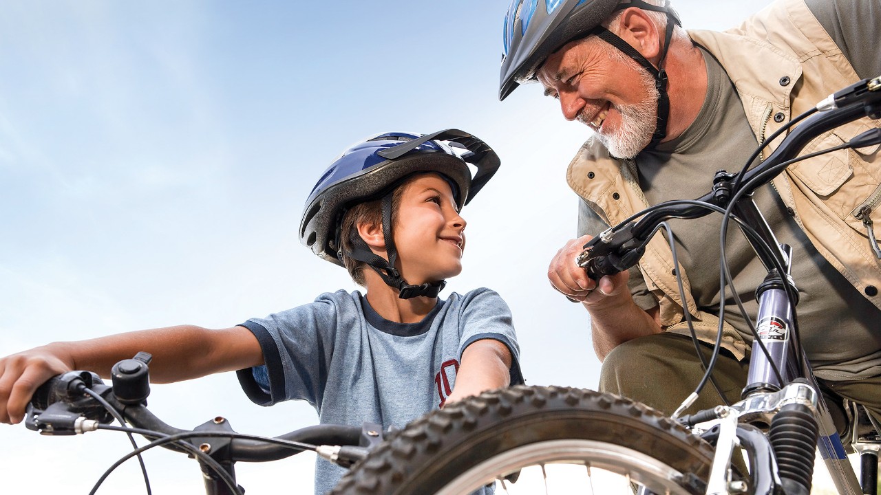 A grandpa and his grandchild are riding bikes; image used for HSBC mutual funds page.