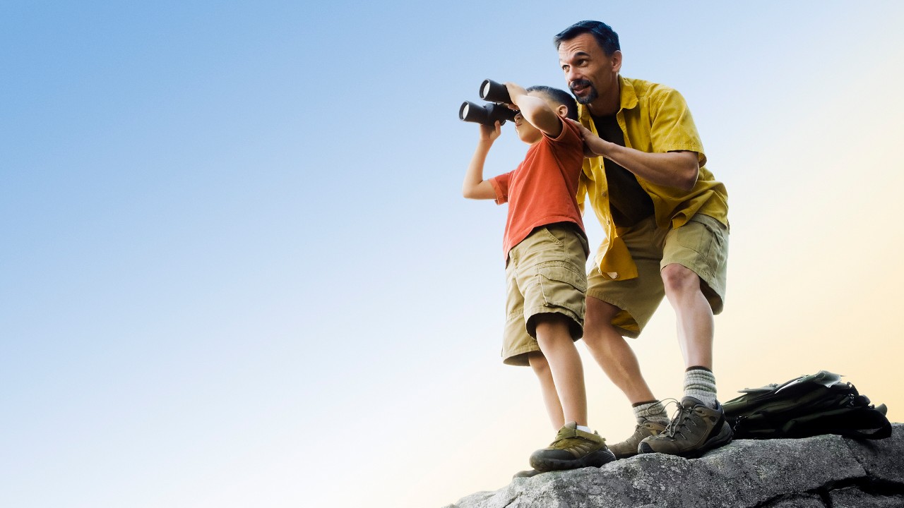 Father and son looking up the sky with binoculars; image used for HSBC Spend wisely article