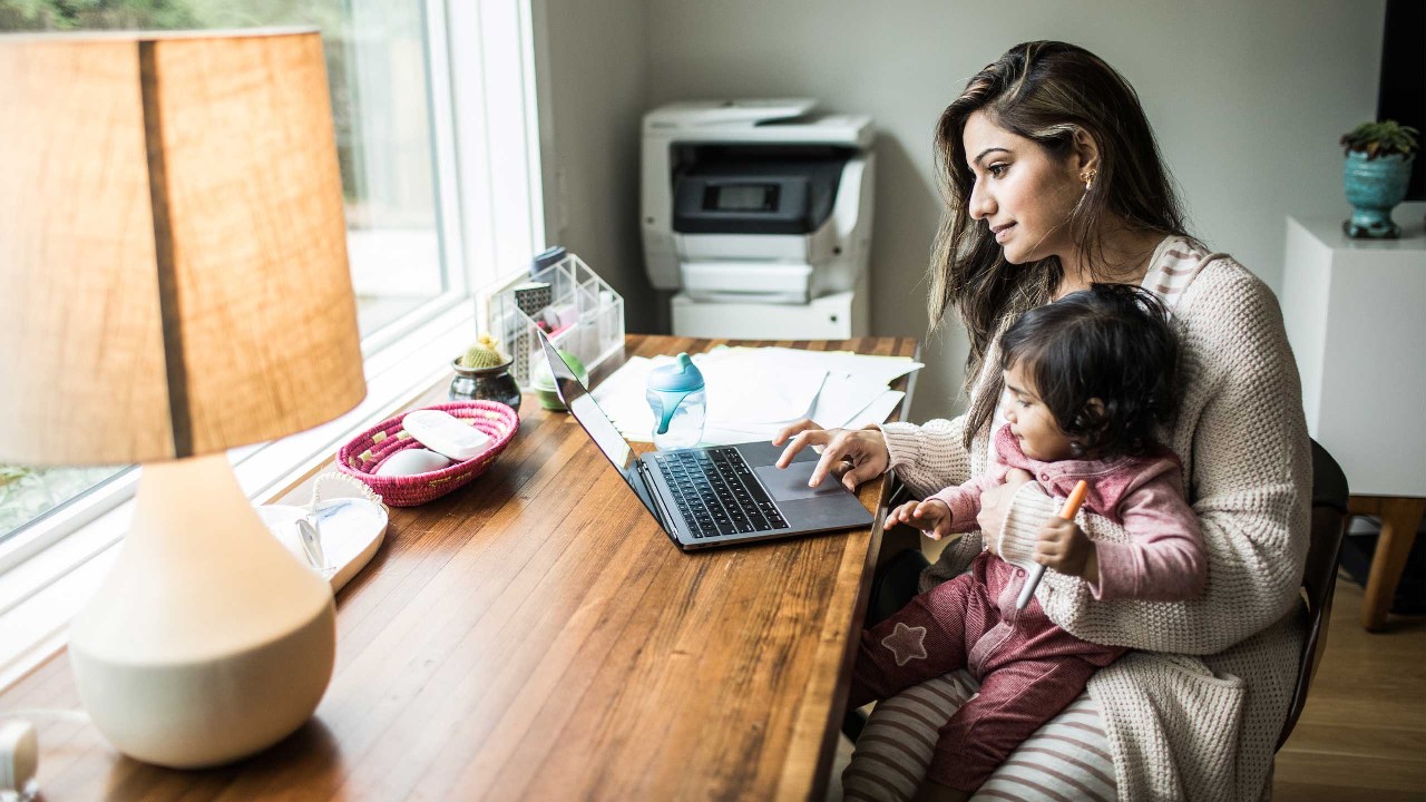Mother multi-tasking with infant daughter in the living room; image used for HSBC Smart Home Loan page