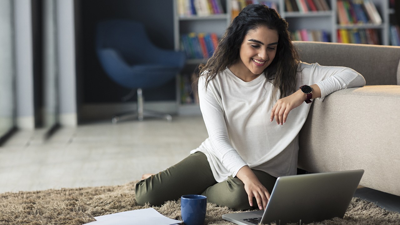 A woman relax using laptop in the living room; image used for HSBC India Live within your means article