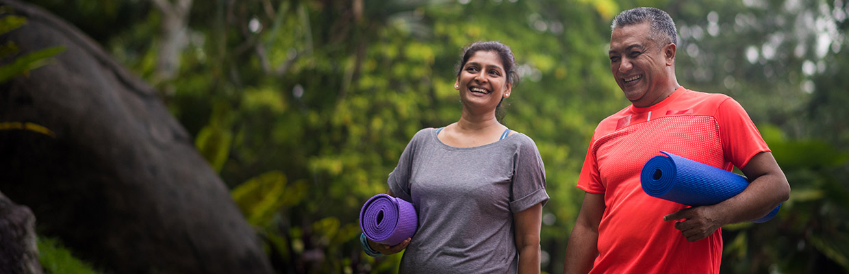 Man and woman walking with yoga mats