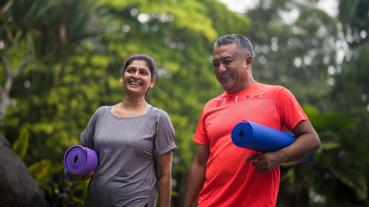 Man and woman walking with yoga mats