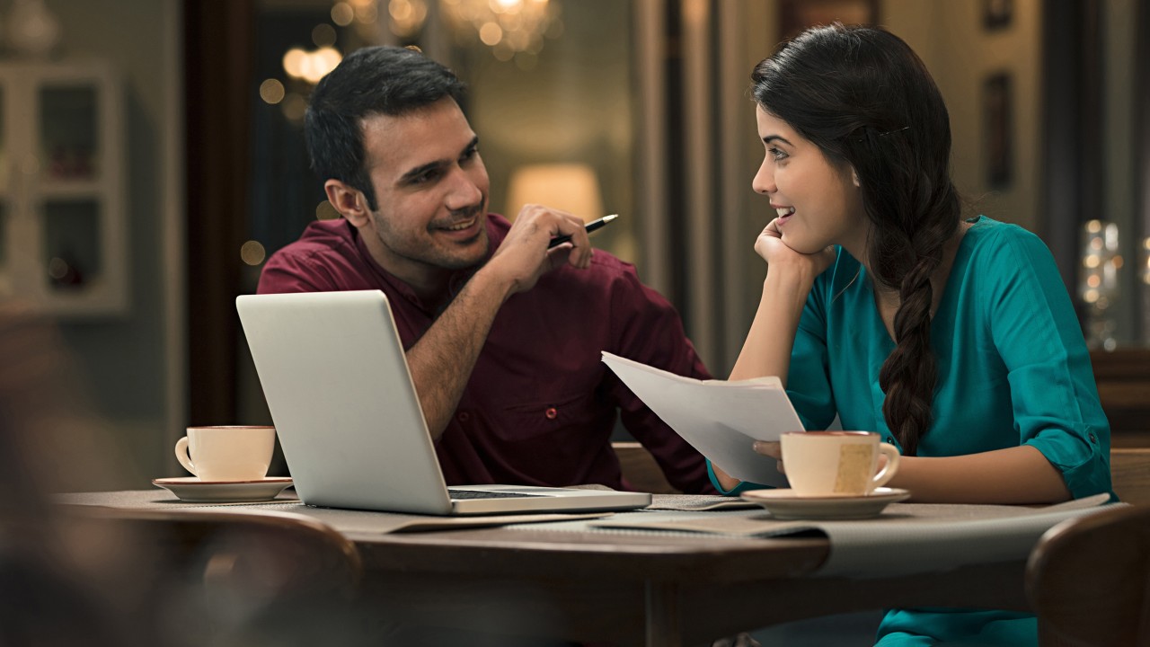 A man and woman chatting in a coffee shop; image used for HSBC Amazon Bill Pay credit card offer