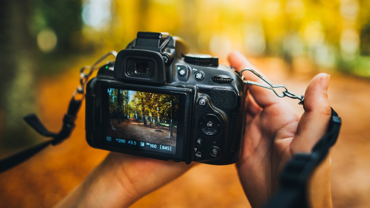 A man is taking a picture with a camera; image used for HSBC retail investment fund page.