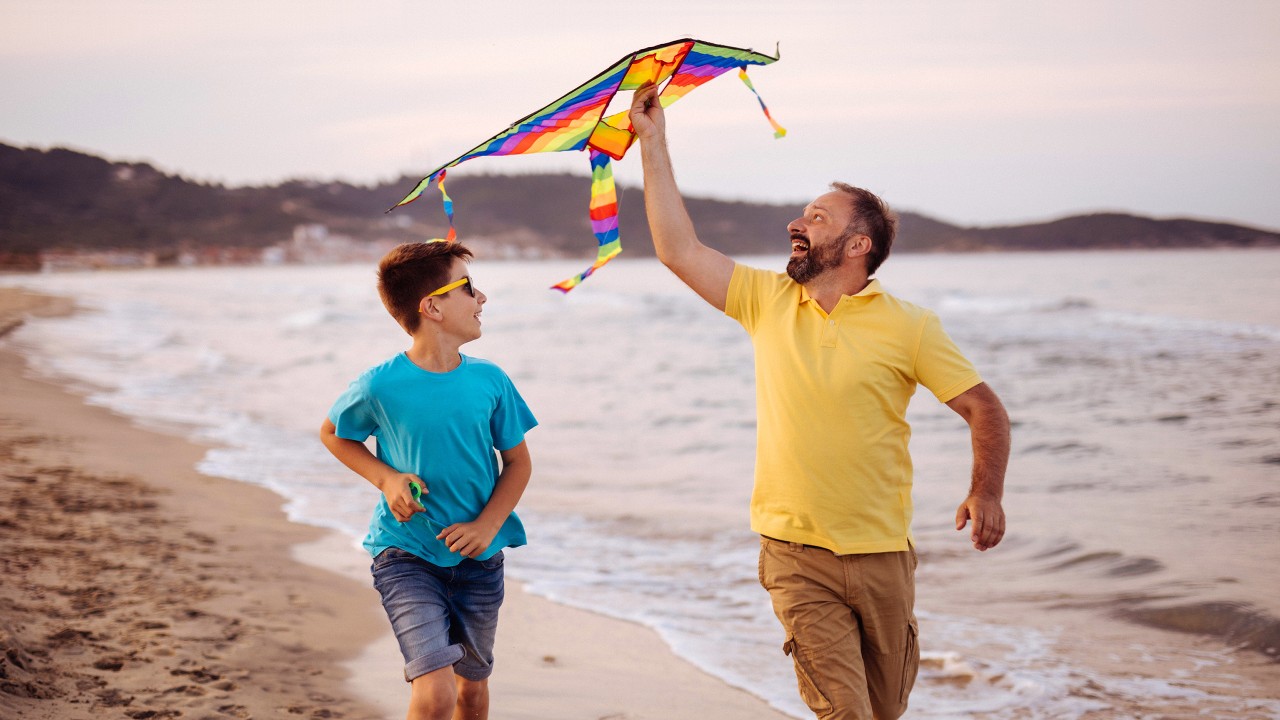 Father and son flying kite in the beach; image used for HSBC India Protect what matters article