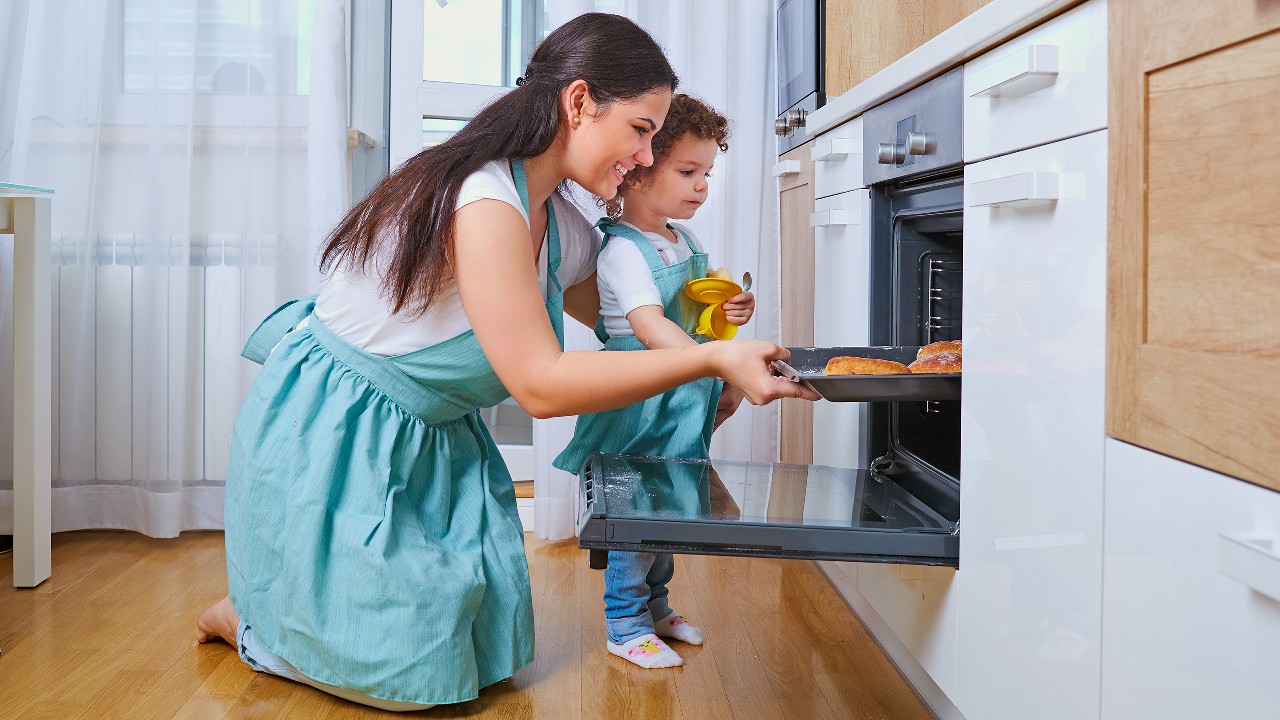 A mom enjoying baking with her infant daughter; image used for HSBC Tata CLiQ offer