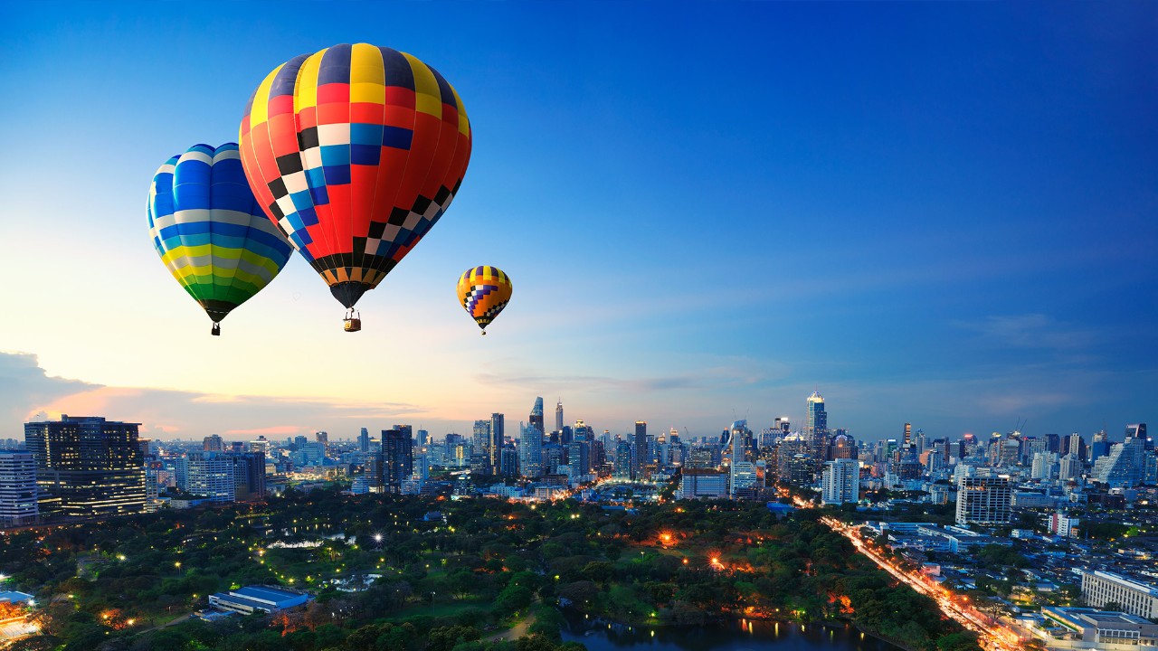 Hot air balloon flying over city