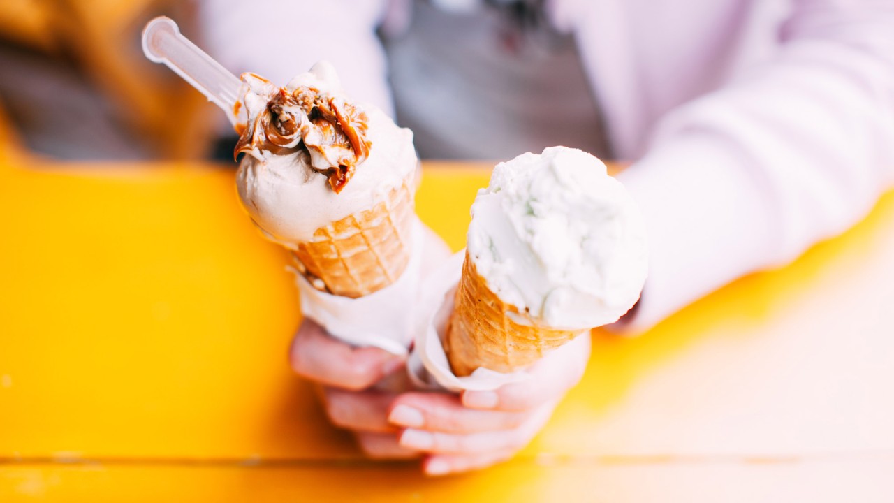 A woman is holding two ice cream cones in her hands; image used for HSBC Credit Card Rewards Programs.