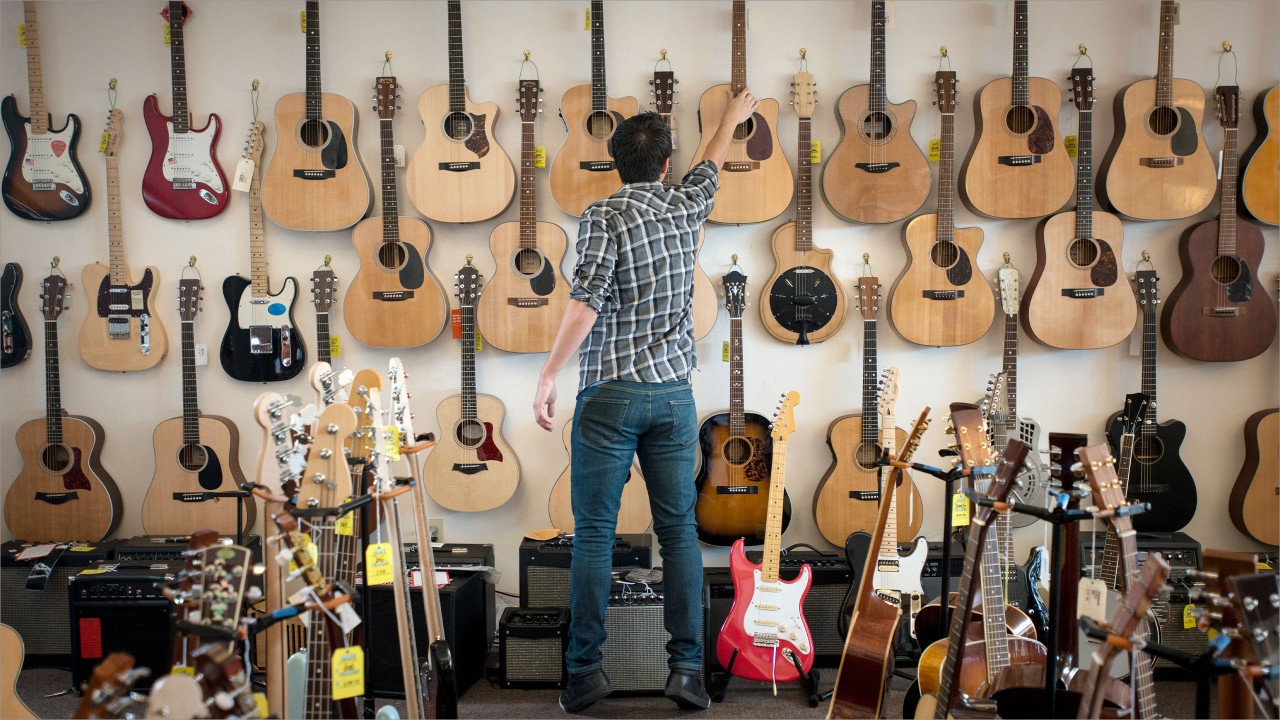 A man is buying guitar; image used for HSBC VISA Smart Value Credit Card.