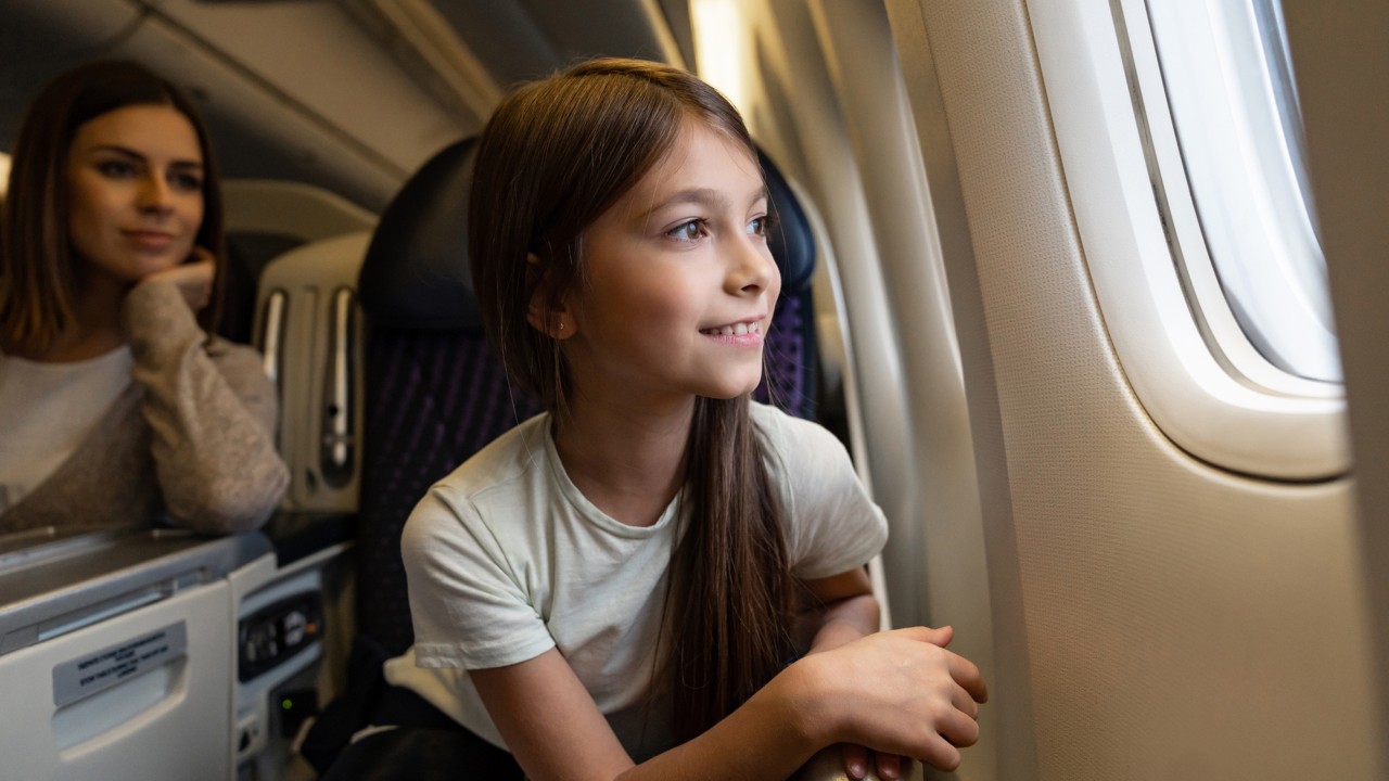 A girl sitting in the plane looking outside; Image used for HSBC International Services Page.