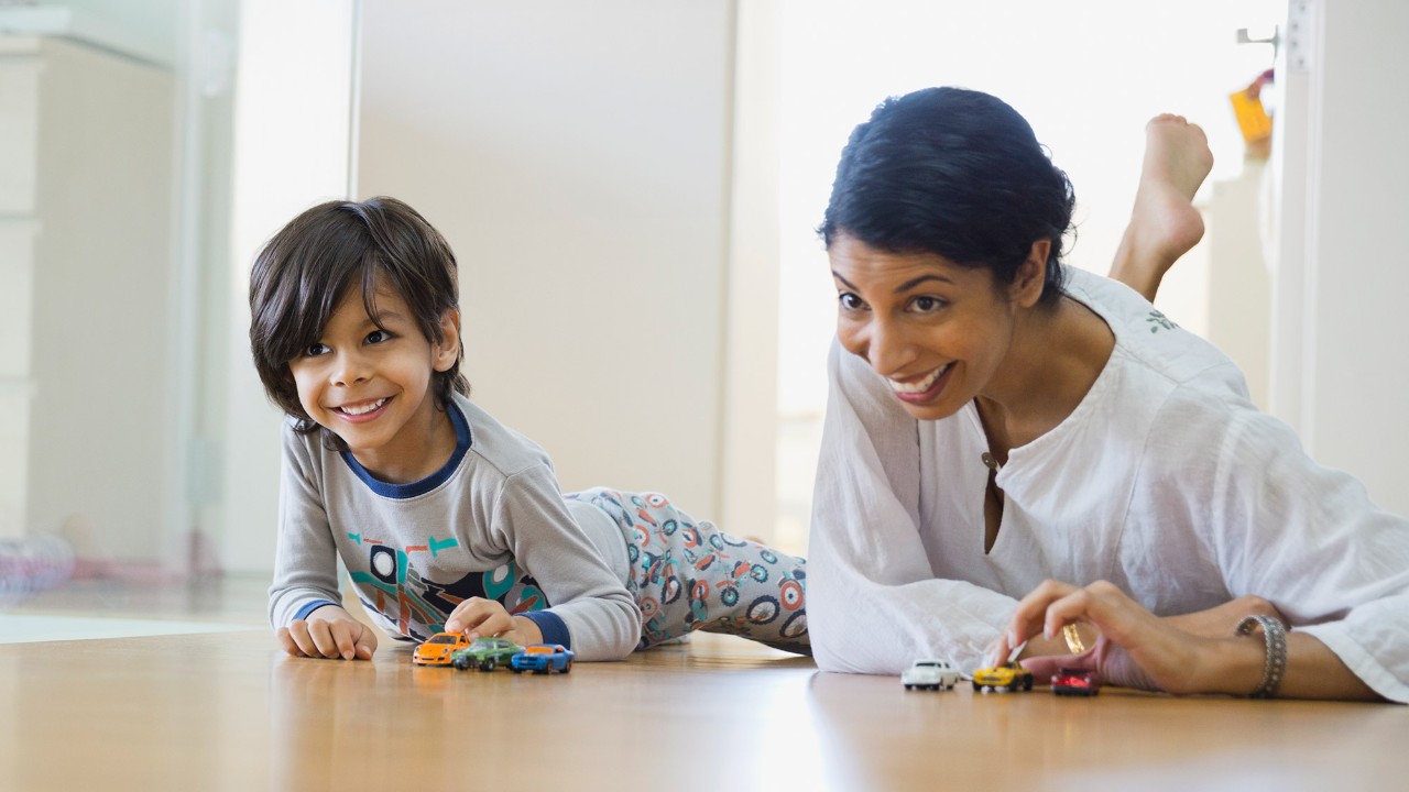 Mother and son playing with toy cars