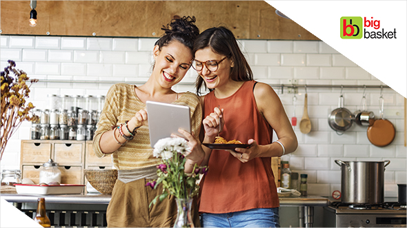 Women chat in kitchen; image used for HSBC bigbasket Offer page.