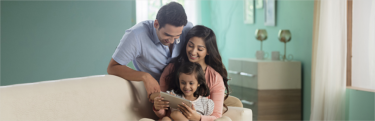 A family looking at the tablet happily at home; image used for HSBC How to do your everyday banking without going to the branch