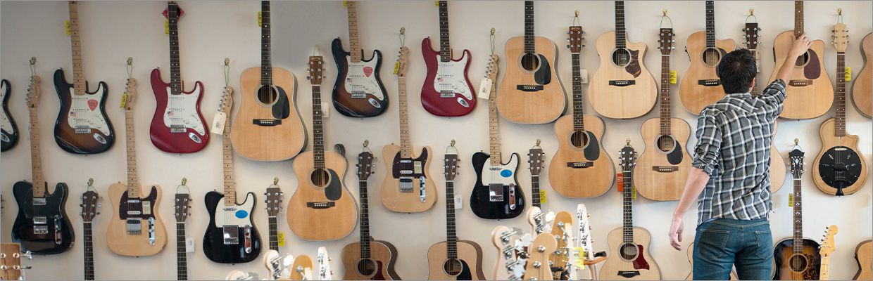 A man is buying guitar; image used for HSBC VISA Smart Value Credit Card.