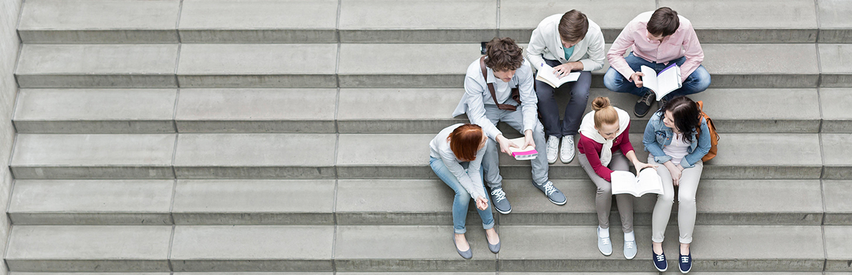 A group of teenagers are sitting together on the stairs; image used for HSBC Looking to study in Canada