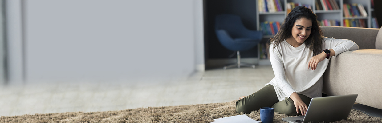 A woman relax using laptop in the living room; image used for HSBC India Live within your means article