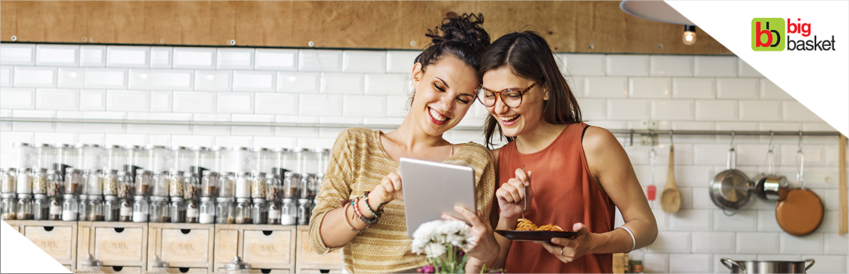 Two girls chatting and eating; image used for HSBC bigbasket Offer page.