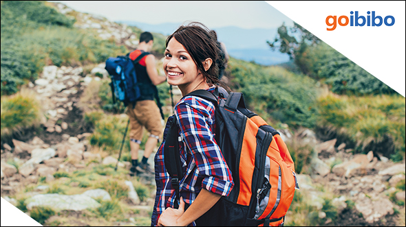One boy and one girl hiking and girl looking behind and smiling; image used for HSBC Goibibo Offer.