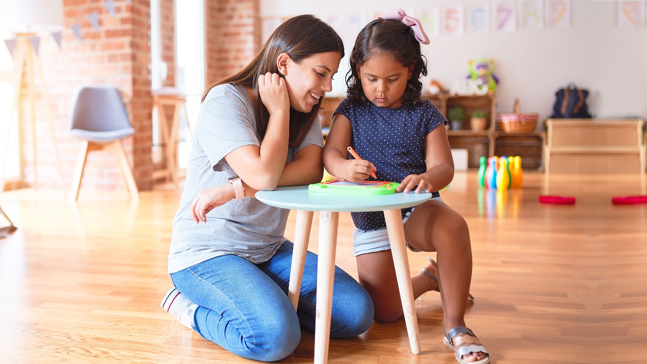 A woman and a little girl drawing in a room; image used for HSBC India iSelect Star Term Plan life insurance