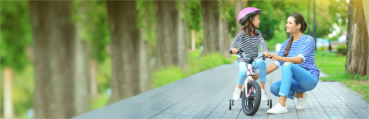 Mother teaching daughter riding bicycle; image used for HSBC India Invest 4G life insurance