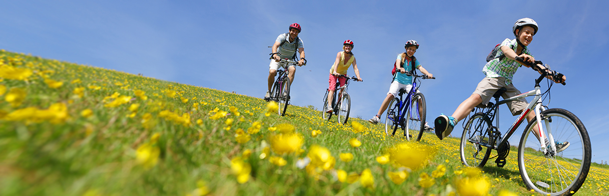 Family riding bike down the hill; image used for HSBC India Personal Banking page