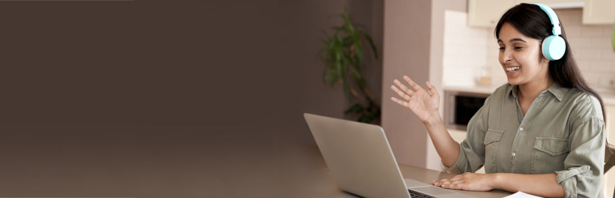 A woman with headphone in front of laptop; image used for HSBC India Video Customer Identification Process page