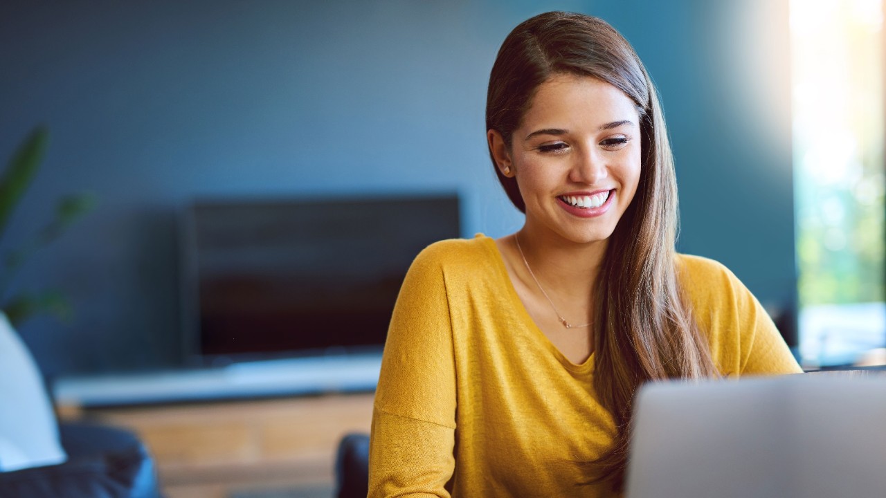 Smiling girl looking at laptop; image used for HSBC Simplypay.